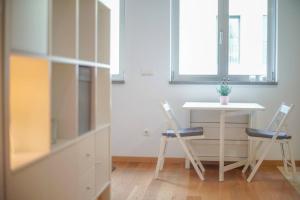 una camera con tavolo e due sedie e una scrivania di GuestReady - Spacious and Modern Studio in Belém! a Lisbona