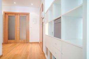 a kitchen with white cabinets and a television and a door at GuestReady - Spacious and Modern Studio in Belém! in Lisbon +15 photos