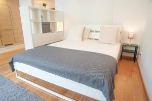 una camera da letto con un grande letto con una coperta grigia di GuestReady - Spacious and Modern Studio in Belém! a Lisbona