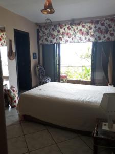 una camera con un grande letto e una finestra di Hostel House 84 a Itajaí