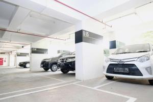 un garaje con dos coches aparcados en él en Sansan Room - Apartemen Gunung Putri Square, en Parungdengdek