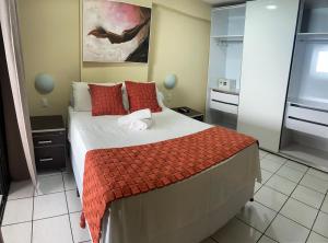 um quarto com uma cama grande e almofadas vermelhas em Ponta Neg Paradise Flat em Natal