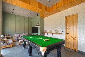 a room with a pool table in a room at SaffronStays Aruunoday - 4BR with Theatre, Deck & Bonfire in Bhīm Tāl
