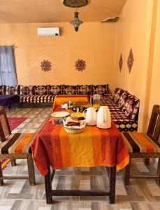 ein Wohnzimmer mit einem Tisch und einem Sofa in der Unterkunft Riad family in Merzouga