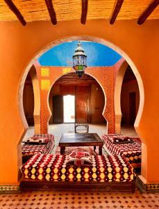 Zimmer mit 2 Betten und einem Tisch in der Unterkunft Riad family in Merzouga