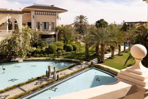 een villa met een zwembad en palmbomen bij Palais Ronsard Relais & Chateaux in Marrakesh