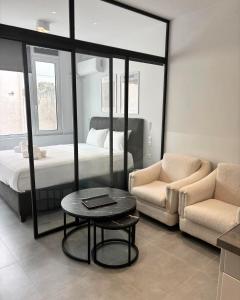 a bedroom with a bed and a table and a chair at JV Athens in Athens