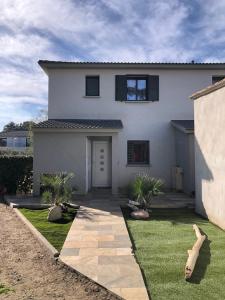 a white house with a grass yard at maison de vacance en corse in Borgo +10 photos