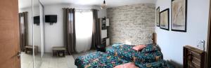 a bedroom with two beds and a brick wall at maison de vacance en corse in Borgo
