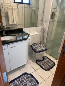 uma casa de banho com WC, chuveiro e 2 tapetes. em Ponta Neg Paradise Flat em Natal