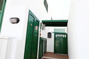 ヤイサにあるMi Pescaitoの白い建物に緑のドアが2つ