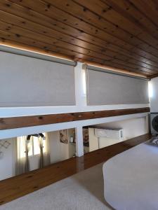 a bedroom with a bed and a wooden ceiling at Secret Garden Petite Home Lagonissi Attiki in Kalívia Thorikoú