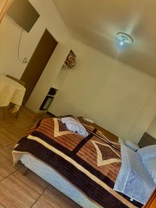 a bedroom with a bed with a striped blanket on it at Hotel CasaBlanca in Santana do Livramento