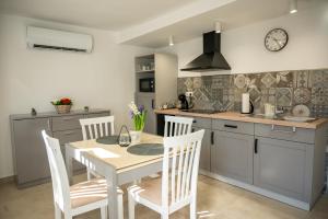 a kitchen with a table and chairs in a kitchen at Tündérkert Apartman in Gyula
