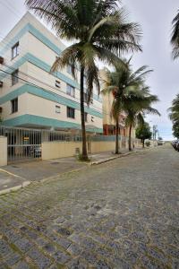 une rue avec des palmiers en face d'un bâtiment dans l'établissement 50 m da Praia do Forte em Cabo Frio 2 quartos cozinha garagem wi fi para ate 8 pessoas!, à Cabo Frio