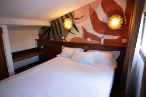 a bedroom with a bed with two mirrors on the wall at Residence Castell'Verde in Porto-Vecchio
