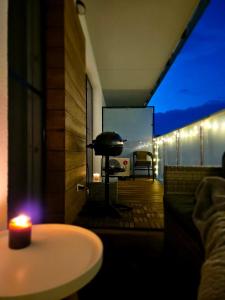 a candle sitting on top of a balcony with a table at Apartament Mandala Grzybowo in Grzybowo