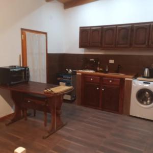 uma cozinha com uma mesa e uma máquina de lavar roupa em La Blanca em Mercedes
