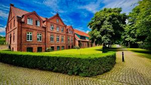 een groot bakstenen gebouw met een groene heg ervoor bij Schloss Lüdersburg Golf & Spa in Lüdersburg