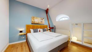 a bedroom with a white bed and a blue wall at Apartment Senftenberg - 1907 in Senftenberg