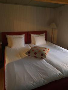 uma cama branca com uma cabeceira vermelha e uma almofada em Brösarps Gästgifveri & SPA em Brösarp