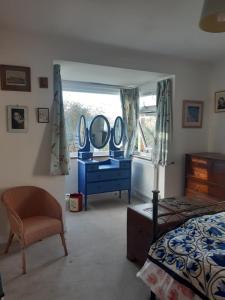 a bedroom with a bed and a blue dresser with mirrors at Marlow in Swanage +36 photos