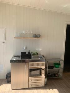 a kitchen with a sink and a stove at Bryggstuga med privat bastu in Norrtälje