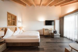 Habitación de hotel con cama y TV en Hotel Gasserhof en Bressanone