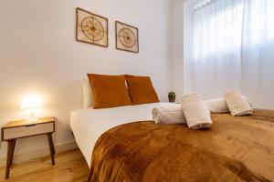 een slaapkamer met een groot bed met 2 kussens bij GuestReady - Dazzling Apt with Private Terrace in Lissabon