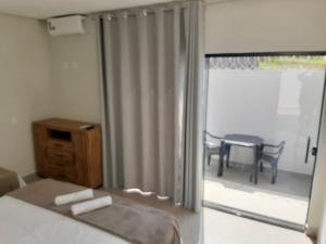 聖若昂－巴蒂斯塔－杜格羅里亞的住宿－Pousada Lobo Guará，一间卧室配有一张床,阳台配有桌子