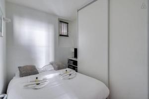 una camera con letto bianco e specchio di GuestReady - Amazing Le Marais Flat - 2 mins to Hôtel de Ville a Parigi