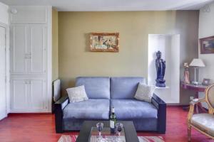 un soggiorno con divano blu e tavolo di GuestReady - Amazing Le Marais Flat - 2 mins to Hôtel de Ville a Parigi