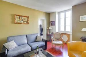 un soggiorno con divano blu e sedia di GuestReady - Amazing Le Marais Flat - 2 mins to Hôtel de Ville a Parigi