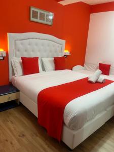 a bedroom with a large bed with red walls at Hotel Veronese in Genoa