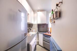 een keuken met een koelkast en een wastafel bij GuestReady - Modern flat near Place De La Bastille in Parijs