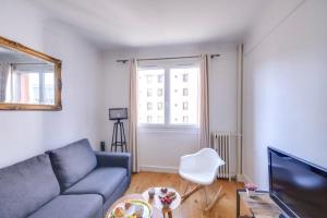 een woonkamer met een bank en een tv bij GuestReady - Modern flat near Place De La Bastille in Parijs
