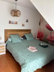 - un lit avec une couette verte dans une chambre dans l'établissement Grand appartement lumineux 4 pers. / vue mer / Wifi inclus, à Quiberon