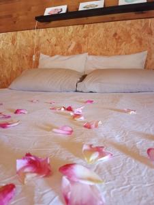 un lit avec des fleurs roses sur lui dans l'établissement la caseta viva, à Olvan