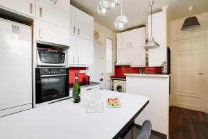 uma cozinha com armários brancos e um balcão branco em GuestReady - Amazing 2BR Flat near Passy Village em Paris