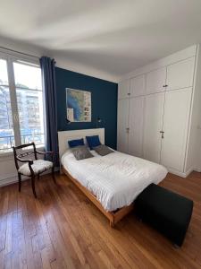 um quarto com uma cama grande e uma cadeira em GuestReady - Amazing 2BR Flat near Passy Village em Paris
