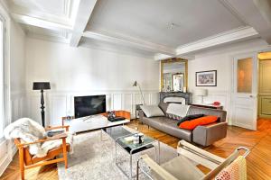- un salon avec un canapé et une table dans l'établissement GuestReady - Luxury Apartment - Paris Centre, à Paris