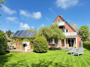 a house with solar panels on the lawn at Hotel Garni Dünennest in Sankt Peter-Ording