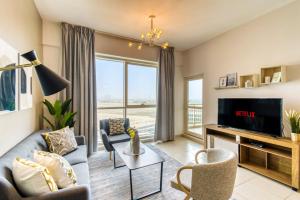 uma sala de estar com um sofá e uma televisão em GuestReady - Sunny Delights em Dubai