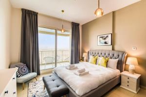 um quarto com uma cama grande e uma varanda em GuestReady - Sunny Delights em Dubai