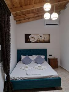 a bedroom with a bed with a blue headboard at Casa Ioanna in Azoyirás