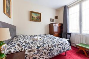 - une chambre avec un lit avec deux animaux rembourrés dans l'établissement GuestReady - Wonderful Flat Located in the Heart of the 15th District, à Paris