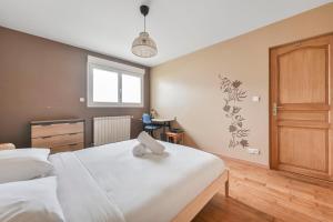 a bedroom with a white bed with a towel on it at La Coquette - Maison 10p - Paris & Disney in Champigny-sur-Marne