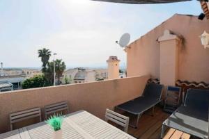 a balcony with tables and chairs on a roof at Casa,Solarium,Barbacoa,Piscina in Gran Alacant