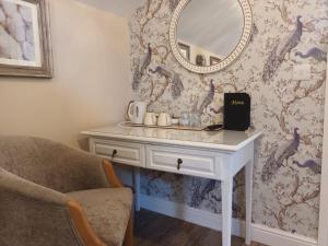 a dressing table with a mirror and a chair at The Renishaw Rooms in Renishaw