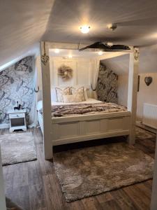 um quarto com uma cama de dossel em The Renishaw Rooms em Renishaw